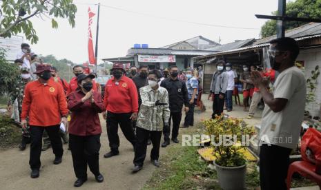 Ketua DPR Puan Maharani (kedua kiri) bersama Kepala BIN Budi Gunawan (kiri) menyapa warga saat kegiatan vaksinasi door to door di Setu Sela, Cibinong, Kabupaten Bogor, Jawa Barat, Rabu (29/9). Badan Intelijen Negara mengadakan kegiatan vaksinasi door to door untuk mempermudah masyarakat mendapatkan vaksin Covid-19 guna percepatan penanganan Covid-19.