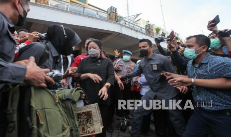 Ketua DPR Puan Maharani (tengah) berjalan keluar Pasar Tambahrejo, Surabaya, Jawa Timur, Rabu (2/3/2022). Kunjungan kerja Ketua DPR di pasar itu untuk mengetahui secara langsung harga bahan pokok dan ketersediaannya. 