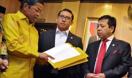 Ketua DPR Setya Novanto ( kanan) menyimak pembacaan putusan sela PTUN oleh Sekjen Partai Golkar kubu Aburizal Bakrie , Idrus Marham (kiri) disaksikan Wakil Ketua DPR Fadli Zon (tengah), Jakarta, Kamis (2/4).