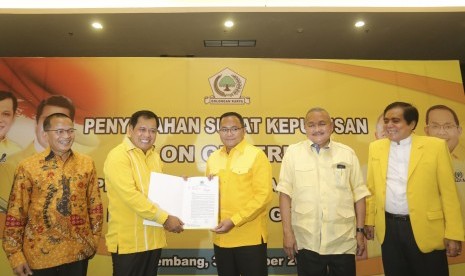 Ketua Harian DPP Partai Golkar Nurdin Halid (kedua kiri) menyerahkan surat keputusan Calon Gubernur kepada Bupati Musi Banyuasin (MUBA) Dodi Reza Alex Noerdin yang disaksikan oleh Ketua DPD Partai Golkar Provinsi Sumatera Selatan Alex Noerdin (kedua kanan), Ketua Pemenangan Pemilu Partai Golkar WIlayah dua Darul Siska (kiri) dan Ketua Harian DPD Partai Golkar Provinsi Sumsel di Palembang, Sumatera Selatan, Selasa (31/10). 