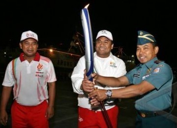 Ketua Harian INASOC (Indonesia SEA Games Organizing Comittee), Rahmad Gobel (tengah) bersama Panglima Komando Lintas Laut Militer (Pangkolinlamil), Laksda TNI Agung Pramono memegang api Obor SEA Games XXVI disaksikan oleh mantan atlet bulutangkis, Icuk Sug