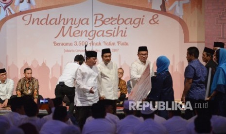 Ketua Himpunan Bank-Bank Milik Negara (Himbara) yang juga Dirut BTN Maryono (kiri) bersama Dirut BRI Suprajarto (kedua kiri) dan Dirut Bank Mandiri Kartika Wirjoatmodjo (keempat kiri) memberikan bantuan pendidikan kepada Yayasan Baidhaul Ahkam disaksikan Menteri BUMN Rini Soemarno (ketiga kiri) dalam acara buka puasa bersama Himbara di Jakarta, Kamis (15/6). 