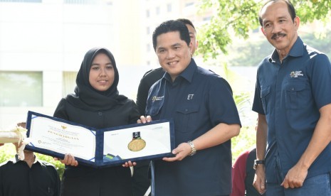 Ketua Inasgoc Erick Thohir (tengah) menyerahkan piagam penghargaan kepada perwakilan Artha Graha Peduli (AGP) anggota Sekuriti Grup Artha (SGA) wanita yang bertugas di arena Pertandingan Asian Games 2018 wilayah Senayan, Dwi Fatma (kiri), di SCBD, Jakarta, Sabtu (23/2).