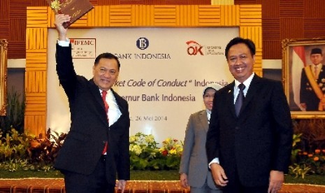 Ketua Indonesia Foreign Exchange Market Committe (IFEMC) Panji Irawan (kanan) menyerahkan Market Code of Conduct kepada Gubernur Bank Indonesia Agus Martowardojo (kiri) dan Dewan komisioner OJK Nurhaida (tengah) di Gedung Bank Indonesia Jakarta, Senin (26/