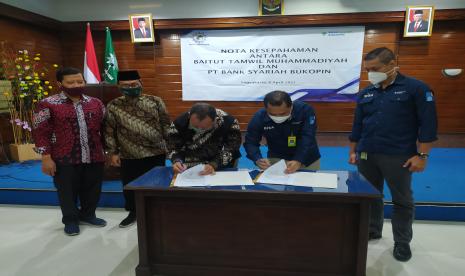 Ketua Induk Baitut Tamwil Muhammadiyah (BTM), Achmad Suud (ketiga kiri) dan Direktur Utama PT Bank Syariah Bukopin (BSB), Dery Januar, menandatangani Nota Kesepahaman antara Baitut Tamwil Muhammadiyah (BTM) dengan PT Bank Syariah Bukopin (BSB) di Kantor Pimpinan Daerah Muhammadiyah (PDM) Kota Yogyakarta, Kamis (8/4).