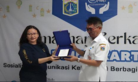 Ketua ISKI DKI Jakarta Dra Anita Wulandari Prasojo M.Si (kiri) dan Lurah Cililitan Sukariya ST MM bertukar cinderamata dalam kegiatan bakti sosial di RPTRA Kelurahan Cililtan, Jakarta Timur, Rabu (3/4/2024). 