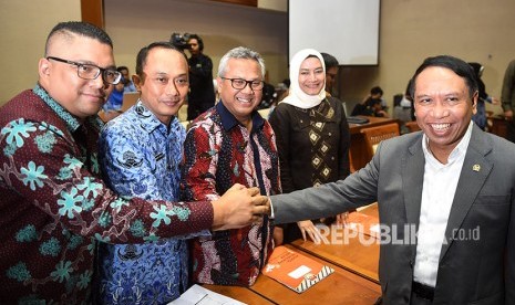 Ketua Komisi II DPR Zainudin Amali (kanan) berjabat tangan dengan Ketua KPU Arief Budiman (tengah), Dirjen Dukcapil Kemendagri Zudan Arif Fakrulloh (kedua kiri), Anggota Bawaslu Fritz Edward Siregar (kiri) dan Anggota KPU Evi Novida Ginting Manik (kedua kanan) sebelum mengikuti rapat di Kompleks Parlemen, Senayan, Jakarta, Senin (21/5). 