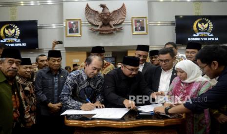 Ketua Komisi VIII DPR RI Ashabul Kahfi bersama Menteri Agama Yaqut Cholil Qoumas menandatangani penetapan Biaya Penyelenggaraan Ibadah Haji (BPIH) usai rapat kerja dengan Komisi VIII DPR di kompleks Parlemen, Senayan, Jakarta, Rabu (15/2/2023). Dalam Rapat tersebut Komisi VIII DPR RI bersama Menteri Agama RI menyepakati Biaya Perjalanan Ibadah Haji (Bipih) atau biaya yang dibayar langsung oleh jemaah haji rata-rata per jemaah sebesar Rp 49.812.700.26 pada tahun  1444 H/2023 M.