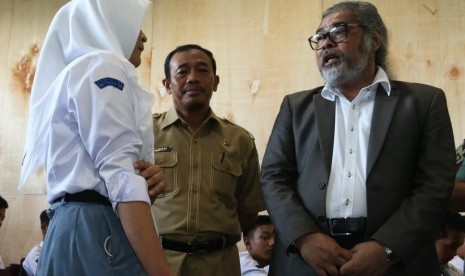 Ketua Komnas Perlindungan Anak Arist Merdeka Sirait (kanan) didampingi Kepala Sekolah SMA Negeri 2 Medan Sutrisno (kedua kanan) berbincang dengan siswa yang masuk tidak melalui sistem Penerimaan Peserta Didik Baru (PPDB) daring saat melakukan kunjungan, di Medan, Sumatra utara, Selasa (17/10). 