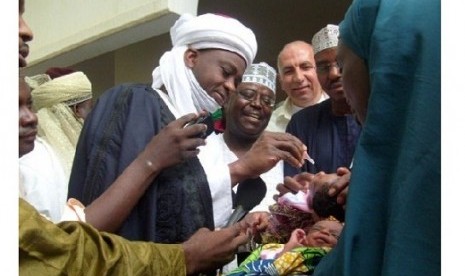 Ketua Komunitas Muslim Nigeria, Sultan of Sokoto, Sa'adu Abubakar mengimunisasi seorang anak.