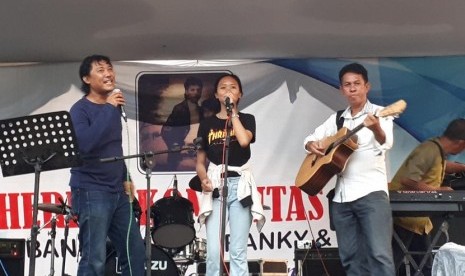 Ketua Komunitas Tembang Balada Franky & Jane (TBF&J), Darul Farhan (kiri), bersama anggota TBF&J Vira dan Johnny Sahilatua (kanan) menyanyikan lagu karya Franky & Jane di Taman Mini Indonesia Indah, Jakarta Timur