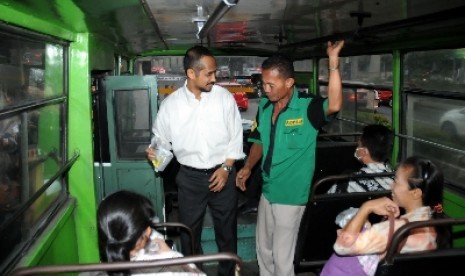 Ketua KPK Abraham Samad memberikan takjil ke penumpang bus di depan gedung KPK, Jakarta, Kamis (24/7). 