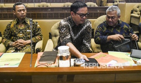 Ketua KPU Arief Budiman (kanan) berbincang dengan Komisioner KPU Viryan (tengah) dan Pramono Ubaid Tanthowi (kiri) sebelum mengikuti Rapat Dengar Pendapat (RDP) dengan Komisi II DPR di Kompleks Parlemen, Jakarta, Senin (2/12/2019). 