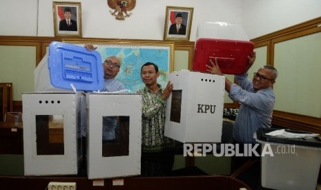 Ketua KPU Arief Budiman (kanan), bersama anggota KPU Pramono Ubaid Tanthowi (tengah), dan Ilham Saputra (kiri) menunjukkan contoh alternatif bentuk kotak suara transparan terbuat dari kertas karton dan Box plastik akan digunakan dalam Pilkada serentak 2018 dan Pemilu 2019 di kantor KPU, Jakarta, Senin (7/8).