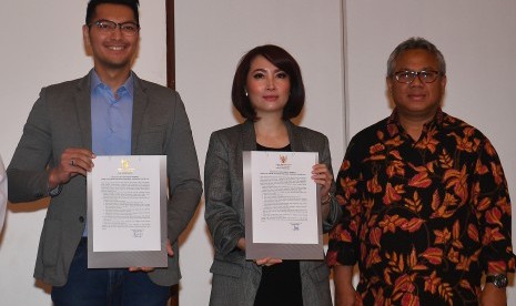 Ketua KPU Arief Budiman (kanan) mendampingi moderator debat Zulfikar Naghi (kiri) dan Retno Pinasti menunjukkan pakta integritas debat keempat calon Presiden Pemilu 2019 di Jakarta, Rabu (27/3/2019).