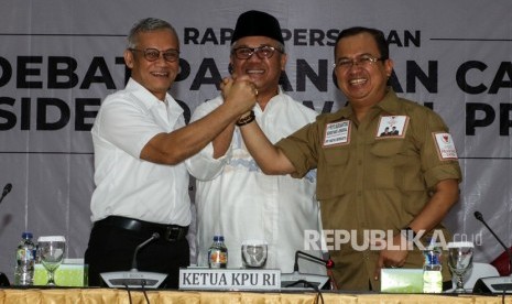 Ketua KPU Arief Budiman (tengah) bersama Direktur Perencanaan Tim Kampanye Nasional Joko Widodo-Ma'ruf Amin, Ario Bimo (kiri), dan Wakil Ketua Badan Pemenangan Nasional Prabowo Subianto-Sandiaga Uno, Priyo Budi Santoso (kanan) bertumpu tangan seusai melakukan rapat persiapan debat pasangan calon presiden dan wakil presiden di Gedung KPU, Jakarta, Jumat (28/12/2018). 