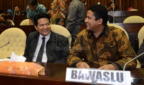 Ketua KPU, Husni Kamil Manik (kiri) berbincang bersama Ketua Bawaslu, Muhammad (kedua kiri) saat rapat dengar pendapat di Komisi II, DPR RI, Jakarta, Senin (22/6). 