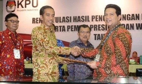  Ketua KPU Husni Kamil Manik memberikan hasil rekapitulasi Pilpres 2014 kepada Jokowi, selaku presiden terpilih di gedung KPU, Jakarta, Selasa (22/7).