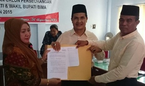 Ketua KPU Kabupaten Bima Nursusila (kiri) menyerahkan berita acara pemeriksaan verfikasi faktual dukungan KTP ke pasangan calon independen bupati Bima Abdul Khayir (tengah) dan calon wakil bupati Bima Abdul Hamid di Kantor KPU Bima, Kamis (20/8)  