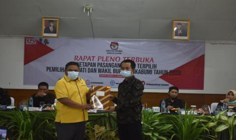 Ketua KPU Kabupaten Sukabumi Ferry Gustaman (kanan) memberikan berkas penetapan bupati dan wakil bupati terpilih kepada paslon, Kamis (21/1)