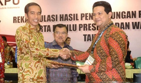 Ketua KPU RI, Husni Kamil Manik memberikan hasil rekapitulasi penghitungan suara nasional dan luar negeri pemilihan Presiden 2014 kepada Presiden terpilih, Joko Widodo di Gedung KPU, Jakarta, Selasa (22/7). 