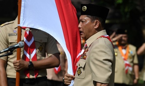 Ketua Kwartir Nasional (Kwarnas) Gerakan Pramuka Budi Waseso memegang bendera merah putih ketika pelantikan ketua dan pengurus Kwarnas Gerakan Pramuka oleh Presiden Joko Widodo di Halaman Tengah Istana Merdeka, Jakarta, Kamis (27/12/2018).