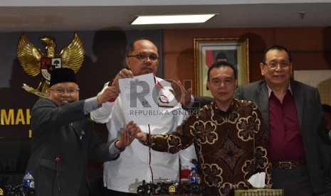  Ketua Mahkamah Kehormatan Dewan (MKD) Surahman Hidayat (kiri), bersama Wakil Ketua MKD Junimart Girsang (kedua kiri) menunjukkan surat pengunduran diri Setya Novanto  di Kompleks Parlemen Senayan, Jakarta, Rabu (16/12).  (Republika/Rakhmawaty La'lang)