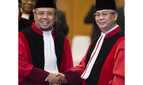 Ketua Mahkamah Konstitusi M. Akil Mochtar (kanan) menerima ucapan selamat dari Hakim Konstitusi Patrialis Akbar (kiri) pada sidang pleno khusus pengucapan sumpah jabatan Ketua Mahkamah Konstitusi di Gedung Mahkamah Konstitusi, Jakarta