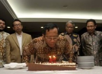 Ketua Mahkamah Konstitusi, Mahfud MD (tengah) meniup lilin saat perayaan ulang tahun di MK, Jakarta, Jumat (13/5).