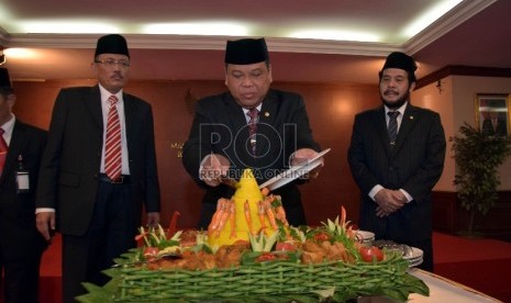 Ketua Mahkamah Konstitusi (MK), Arief Hidayat (tengah) memotong tumpeng pada peringatan Hari jadi MK ke-12 di Jakarta, Kamis (13/8).Republika/Rakhmawaty La'lang