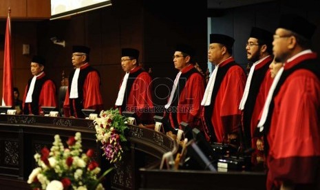  Ketua Mahkamah Konstitusi (MK)  Hamdan Zoelva bersama anggota Hakim MK lainnya menyayikan lagu kebangsaan saat sidang sumpah jabatan di Jakarta, Rabu (6/11).      (Republika/ Tahta Aidilla)