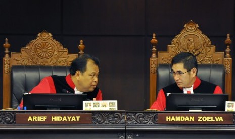 Ketua Mahkamah Konstitusi (MK) Hamdan Zoelva (kanan) berdiskusi dengan Hakim MK Arief Hidayat (kiri) saat memimpin sidang pembacaan putusan sengketa Pemilihan Presiden di Gedung MK, Jakarta, Kamis (21/8).