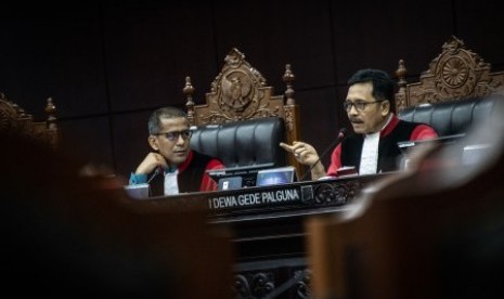 Ketua Majelis Hakim Mahkamah Konstitusi (MK) Saldi Isra (kiri) menyimak penjelasan anggota Majelis Hakim (MK) I Dewa Gede Palguna (kanan) dalam sidang pendahuluan permohonan terkait batas usia calon kepala daerah di Gedung Mahkamah Konstitusi, Jakarta, Rabu (16/10/2019). Sidang tersebut menguji Undang-Undang Nomor 1 Tahun 2015 tentang Penetapan Peraturan Pemerintah Pengganti Undang-Undang Nomor 1 Tahun 2014 tentang Pemilihan Gubernur, Bupati, dan Wali Kota terhadap Undang-Undang Dasar Negara Republik Indonesia 1945. 