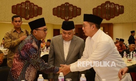 Ketua Majelis Permusyawaratan Rakyat (MPR Zulkifli Hasan (kedua kiri) bersalaman dengan Menteri Agama Lukman Hakim Saifuddin, (kanan), disaksikan oleh Ketua Dewan Pertimbangan MUI Din Syamsuddin (tengah) saat Rapat Kerja Nasional MUI yang ke-2 di Jakarta, 