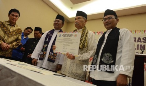 Ketua Majelis Tinggi Adat Betawi Eddie Nalapraya (tengah) bersama Ketua Umum Forum Betawi Rempug (FBR) Luthfi Hakim (kanan) dan Ketua Bamus Betawi Zainuddi (ketiga kanan) menunjukan nota deklarasi damai saat deklarasi damai dan doa lintas agama di Jakarta, Kamis (13/4).