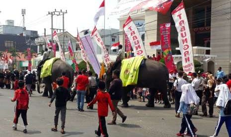 Ketua MPR RI Zulkifli Hasan bersama Ketua INASGOC Erick Thohir bersama dua gajah jinak Waykambas menyambut Kirab Api Obor Asian Games 2018 di Kota Bandar Lampung, Rabu (8/8).  