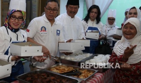   Ketua PAN Zulkifli Hasan (kedua kiri) bersama Perempuan Amanat Nasional (PUAN) membagikan makanan kepada warga Cipinang Pulo di Dapur Iftar Puan Cipinang Jaya, Jakarta Timur, Rabu (14/5). 