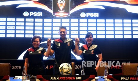 Ketua Panitia Penyelenggara Piala Presiden 2019 Iwan Budianto (tengah) mengangkat tangan bersama Wakil Ketua Harsiwi Achmad (kiri) dan Sekjen PSSI Ratu Tisha Destria (kanan) usai konferensi pers dan drawing Piala Presiden 2019 di Jakarta, Selasa (19/2/2019).