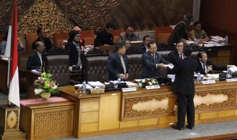 Ketua Panja RUU Pilkada Abdul Hakam Naja (kanan) berjalan saat akan menyerahkan hasil pembahasan komisi II dalam sidang Paripurna di kompleks Parlemen Senayan, Jakarta, Kamis (25/9). (Tahta Adilla/Republika).