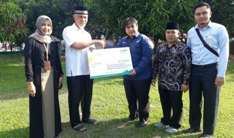 Ketua Pembina Masjid Agung Nurul Iman Padang, yang juga  Walikota Padang,  Mahyeldi Ansharullah (kedua dari kiri) menerima kurban dari yang diserahkan perwakilan Bank Syariah Mandiri (BSM) Kota Padang.