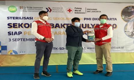 Ketua PMI DKI Jakarta, Drs  H  Rustam Effendi  MSi (kanan) menyerahkan bantuan alat dan bahan disinfektasi dari PMI kepada Sekolah Bakti Mulya 400 yang diterima oleh Ketua Pelaksana Harian Yayasan (KPH) Bakti Mulya 400, Dr Sutrsino Muslimin  MSi, Jumat (3/9).