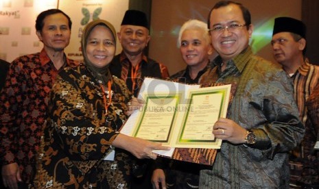 Ketua Presidium ICMI 2014 Priyo Budi Santoso (kedua kanan) menerima berita acara serah terima jabatan dari Ketua Presidium ICMI 2013 Marwah Daud (kedua kiri) di Jakarta, Sabtu (21/12). 