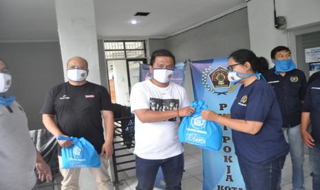 Ketua PWI Kota Bandung Hardiyansyah (tengah) menyalurkan bantuan paket sembako kepada anggota PWI di Kota Bandung dan kelompok masyarakat yang terdampak Covid-19. Bantuan sengaja diserahkan menjelang pemberlakukan Pembatasan Sosial Berskala Besar (PSBB) di Bandung Raya, Selasa (21/4).    