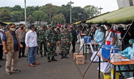 Ketua Satgas Penanganan COVID-19 Letjen TNI Ganip Warsito (kiri memakai rompi) bersama Panglima TNI Marsekal Hadi Tjahjanto (tiga kiri) dan Menteri Kesehatan (Menkes) RI Budi Gunadi Sadikin (dua kiri) meninjau pelaksanaan program Serbuan Vaksin yang diinisiasi oleh Markas Besar (Mabes) TNI Cilangkap di halaman Stadion Gelora Bung Karno (GBK) Jakarta, Ahad (11/7).