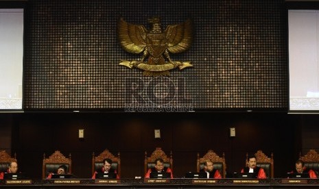 Ketua Sidang Mahkamah Konstitusi Arief Hidayat (keempat kiri) membacakan putusan sidang atas gugatan UU Otoritas Jasa Keuangan (OJK) di Mahkamah Konstitusi, Jakarta, Selasa (4/8).     (Republika/Raisan Al Farisi)