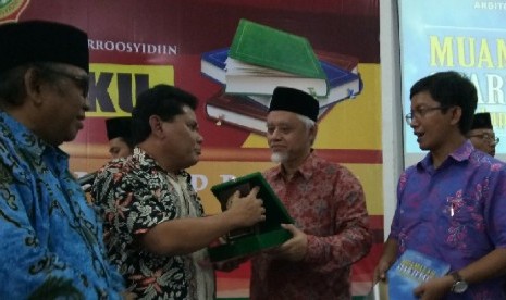 Ketua STAIMI Prof Dr Sudarsono (kedua dari kanan) menyerahkan cendera mata kepada Ketua Komisi Pemberdayaan Ekonomi Umat (KPEU) MUI Azrul Tanjung (kedua dari kiri) disaksikan pakar ekonomi syariah Ardito Bhinadi (kanan) dan Ketua Umum DPP LDII Prof KH Abdullah Syam (kiri).