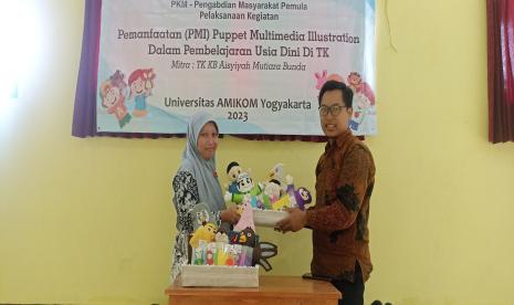 Ketua tim pengabdian Masyarakat Universitas Amikom Yogyakarta, Ali Mustopa (kanan) menyerahkan video multimedia dan boneka tangan kepada TK KB Mutiara Bunda yang diwakili oleh salah satu guru, Amanah dalam acara Pemanfaatan Puppet Media Illustration (PMI) dalam Pembelajaran Usia Dini di TK KB Mutiara Bunda, Mungur, Srimartani, Piyungan, Sleman, DIY, Kamis (7/9/2023).