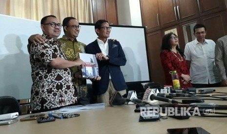 Ketua Tim Sinkronisasi Anies-Sandi, Sudirman Said (kiri) menyerahkan hasil kerja tim sinkronisasi pada pasangan Gubernur-Wakil Gubernur DKI Jakarta terpilih Anies Baswedan (tengah) dan Sandiaga Uno di Jakarta, Jumat (13/10). 