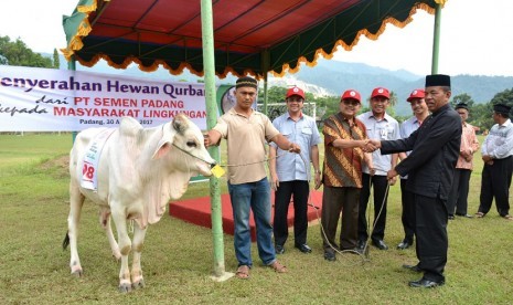 Ketua Umum Baznas Pusat Bambang Sudibyo menyerahkan sapi kurban dari PT Semen Padang secara simbolis kepada Ketua KAN Lubukkilangan Padang, di Lapangan Cubadak Indarung, Rabu (30/8). Pada tahun ini Semen Padang membagikan sebanyak 54 sapi kurban kepada masyarakat.