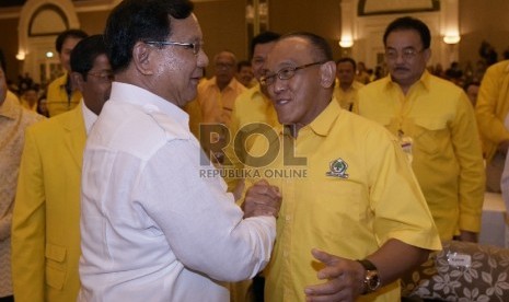 Ketua Umum DPP Partai Golkar Aburizal Bakrie (kedua kanan) bersalaman dengan Ketua Umum Partai Gerindra, Prabowo Subianto (kiri) dalam pembukaan Rapimnas ke VIII Golkar di Jakarta, Jumat (12/6).(ANTARA FOTO/Sigid Kurniawan) 